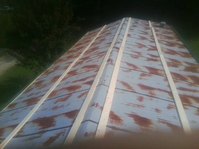 Rusted metal roof panels with new wood purlins before replacement — Storm Damage Roof Repair in Dow City by Roofing Brothers