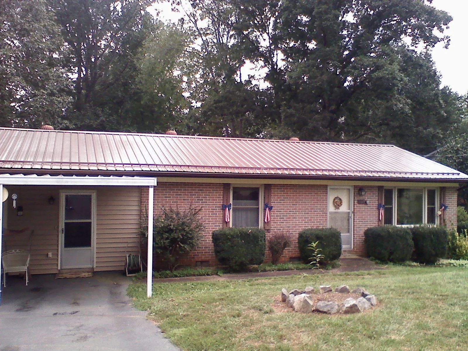 Bronze metal roof and carport on a brick ranch home — Roof Repair work by our crew in Dow City