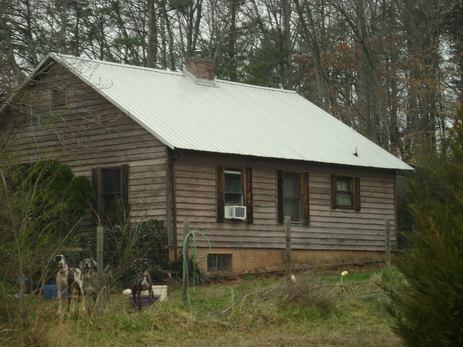 White metal roof on an old wood sided farmhouse, from a Metal Roof Installation job in Dow City